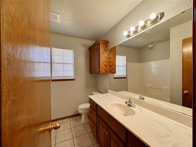 bathroom with tile patterned floors, vanity, a textured ceiling, and toilet