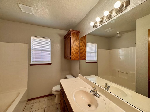 bathroom with tile patterned flooring, a healthy amount of sunlight, toilet, and a textured ceiling