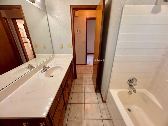 bathroom with tile patterned flooring, vanity, and washtub / shower combination