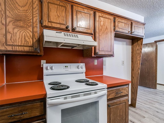 kitchen with electric range, a textured ceiling, and light wood-type flooring