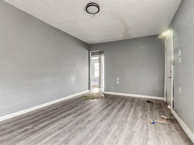 unfurnished room featuring a textured ceiling and light wood-type flooring