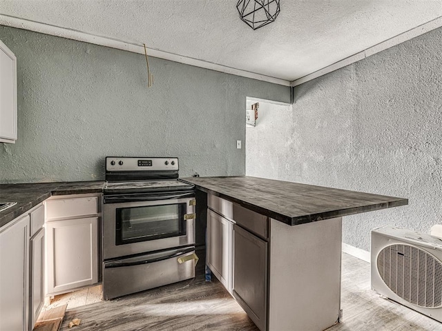 kitchen with electric range, kitchen peninsula, white cabinets, and light wood-type flooring