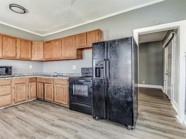 kitchen featuring crown molding, sink, light hardwood / wood-style flooring, and black appliances