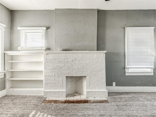 interior details featuring a brick fireplace and carpet flooring