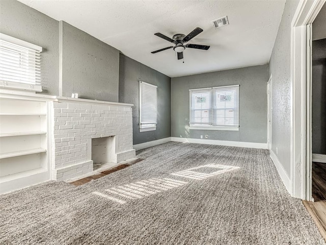 unfurnished living room with carpet floors, a fireplace, and ceiling fan