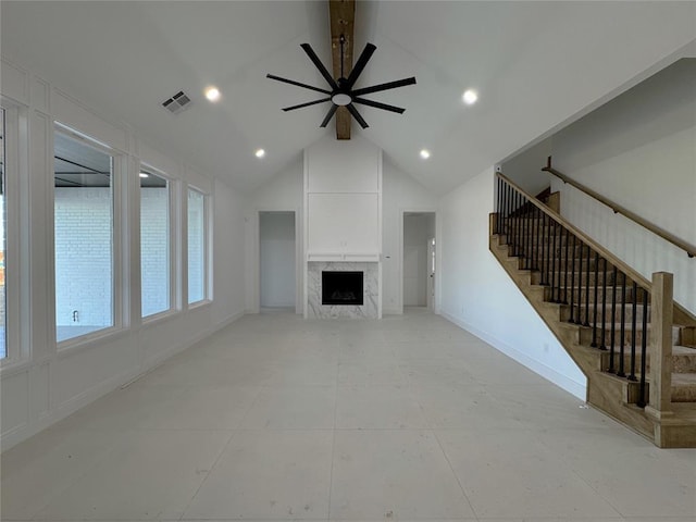 unfurnished living room featuring lofted ceiling with beams, ceiling fan, and a high end fireplace