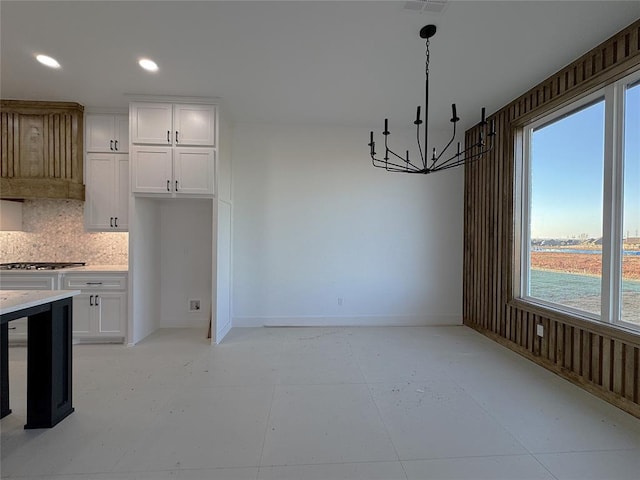 unfurnished dining area featuring a water view and a chandelier