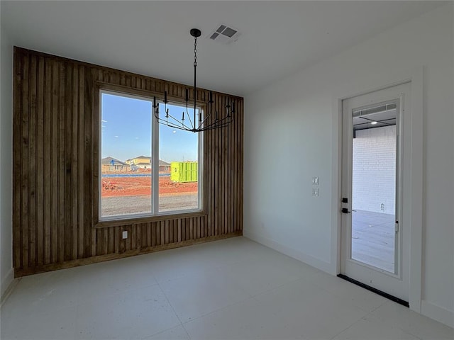 unfurnished dining area featuring a notable chandelier