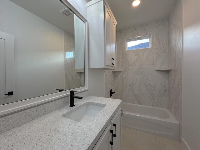 bathroom with tiled shower / bath and vanity