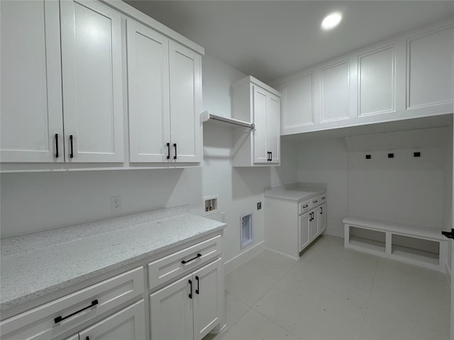 laundry area featuring cabinets, electric dryer hookup, washer hookup, and light tile patterned floors