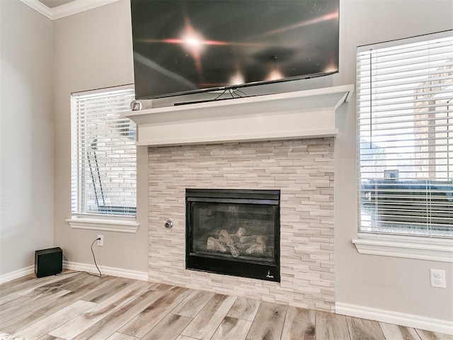 room details featuring a tile fireplace, crown molding, and hardwood / wood-style flooring