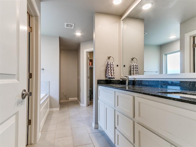 bathroom with a bathtub, tile patterned flooring, and vanity