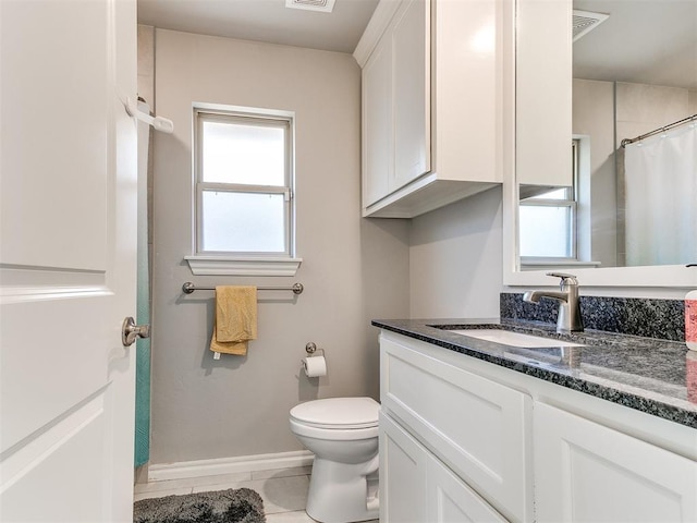 bathroom featuring tile patterned flooring, vanity, and toilet