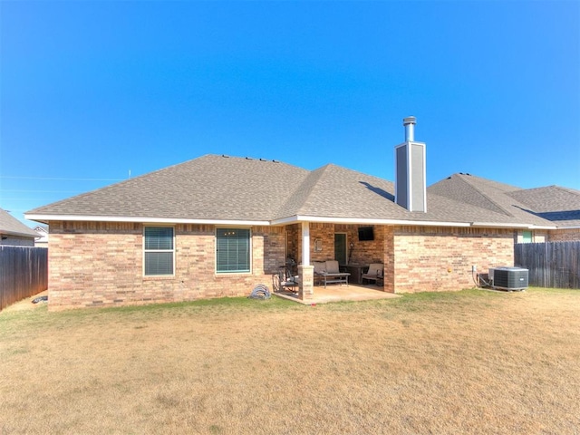 back of property with a yard, cooling unit, and a patio area