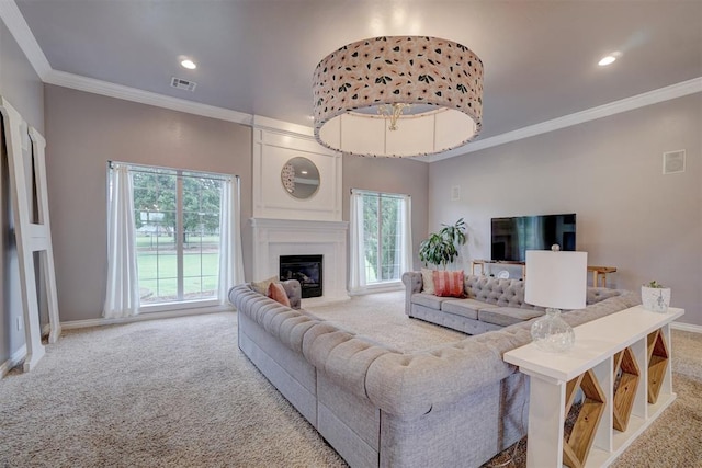 living room with carpet floors, a large fireplace, a wealth of natural light, and crown molding