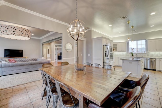 dining area with a chandelier, light tile patterned floors, crown molding, and sink