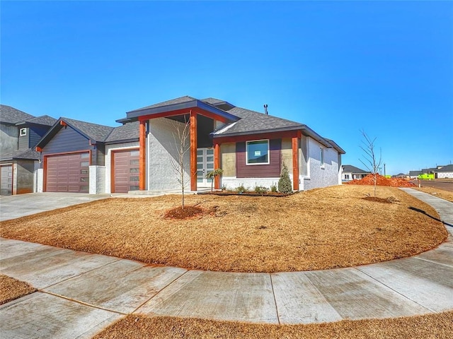 view of front facade with a garage, brick siding, and driveway