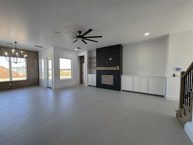 unfurnished living room featuring visible vents, a large fireplace, baseboards, recessed lighting, and ceiling fan with notable chandelier