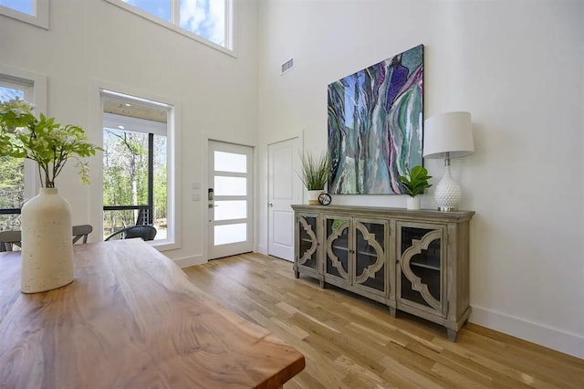 foyer entrance with light wood-type flooring and a high ceiling