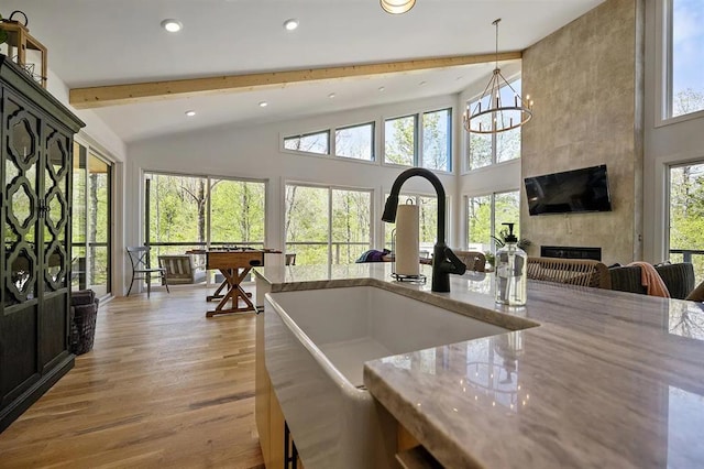 kitchen with beam ceiling, pendant lighting, a healthy amount of sunlight, and sink