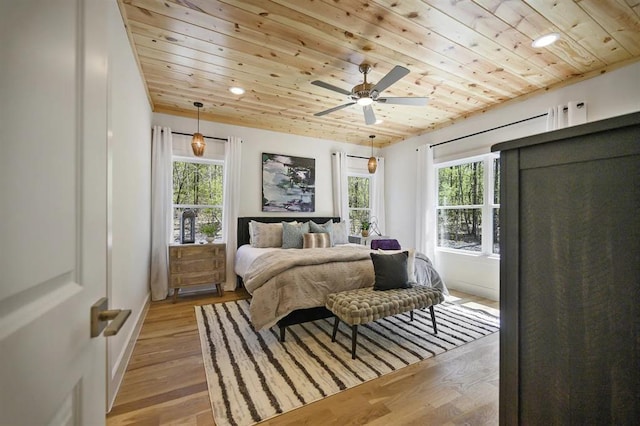 bedroom featuring hardwood / wood-style flooring, wood ceiling, and multiple windows