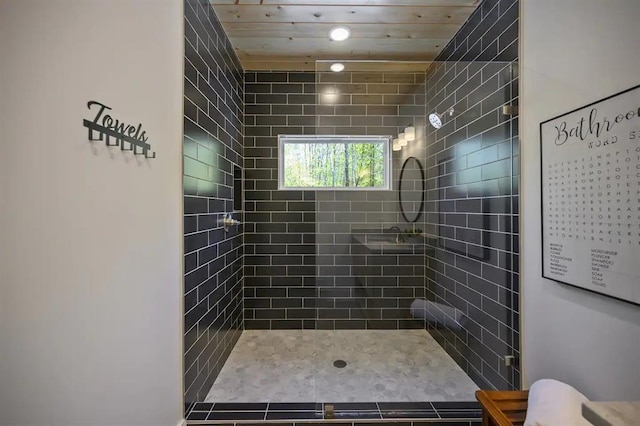 bathroom featuring tiled shower, tile patterned flooring, and wood ceiling