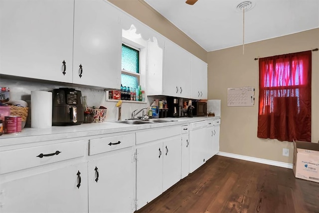 kitchen with sink, dark wood-type flooring, backsplash, white dishwasher, and white cabinets