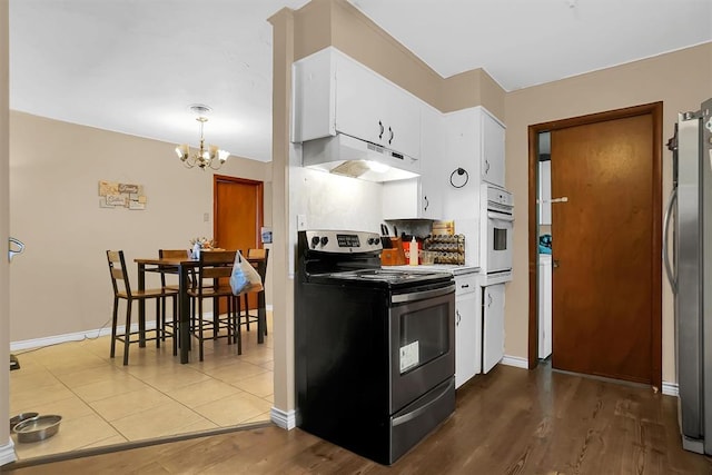 kitchen featuring electric range, white oven, stainless steel fridge, white cabinets, and hardwood / wood-style flooring