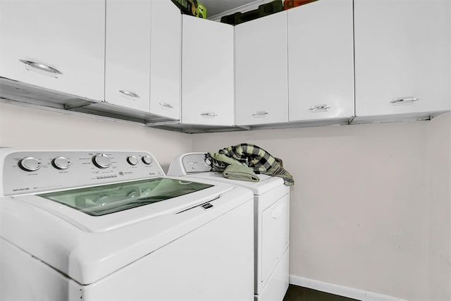 laundry room featuring washer and dryer and cabinets