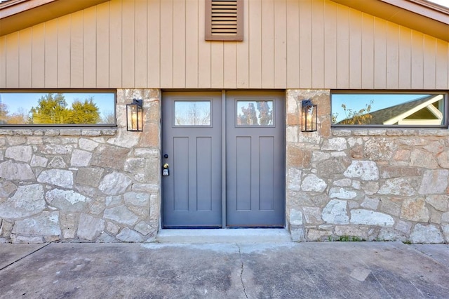 doorway to property featuring stone siding