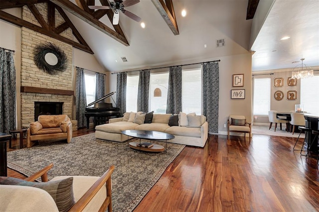 living room with high vaulted ceiling, ceiling fan with notable chandelier, dark hardwood / wood-style floors, a fireplace, and beam ceiling