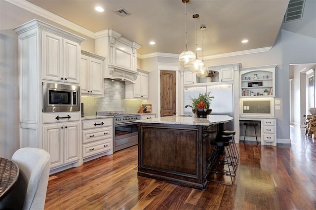 kitchen with built in appliances, light stone countertops, dark wood-type flooring, and decorative light fixtures