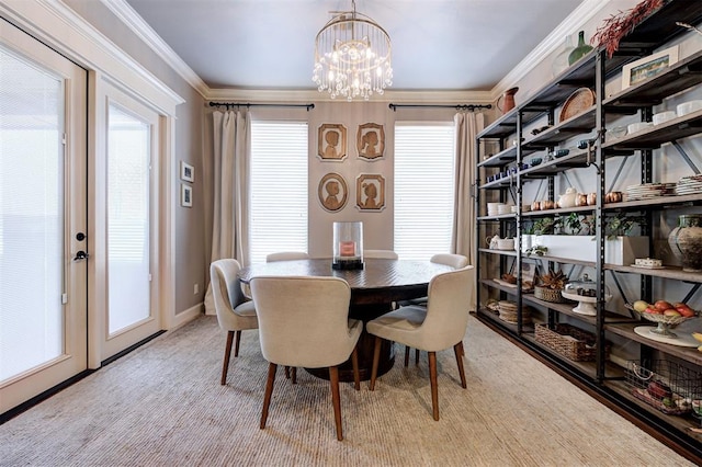 dining room with a chandelier, light carpet, and ornamental molding