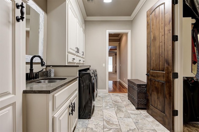 interior space with separate washer and dryer, white cabinetry, crown molding, and sink