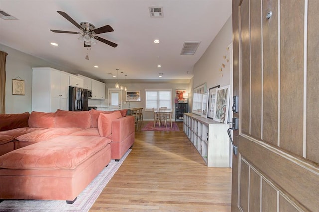 living room featuring ceiling fan and light hardwood / wood-style floors