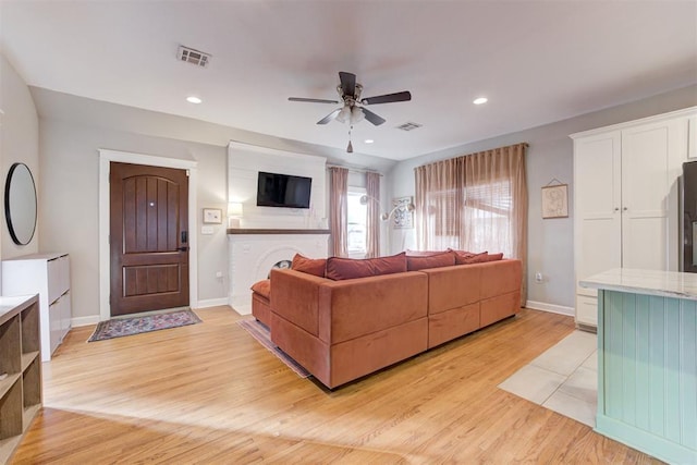 living room with ceiling fan and light hardwood / wood-style floors