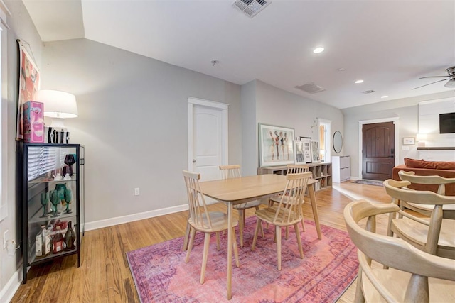 dining area featuring ceiling fan, vaulted ceiling, and light hardwood / wood-style flooring