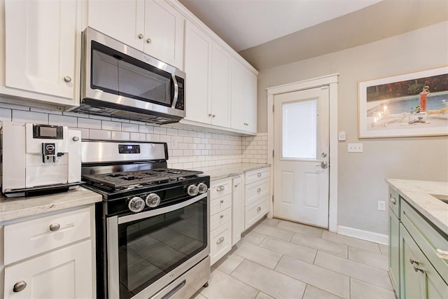 kitchen with white cabinets, stainless steel appliances, and tasteful backsplash