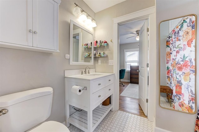 bathroom featuring hardwood / wood-style flooring, ceiling fan, toilet, and vanity