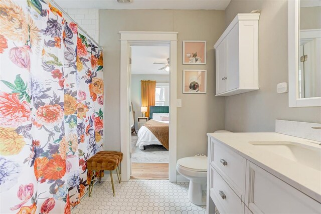 bathroom with tile patterned flooring, vanity, toilet, and ceiling fan