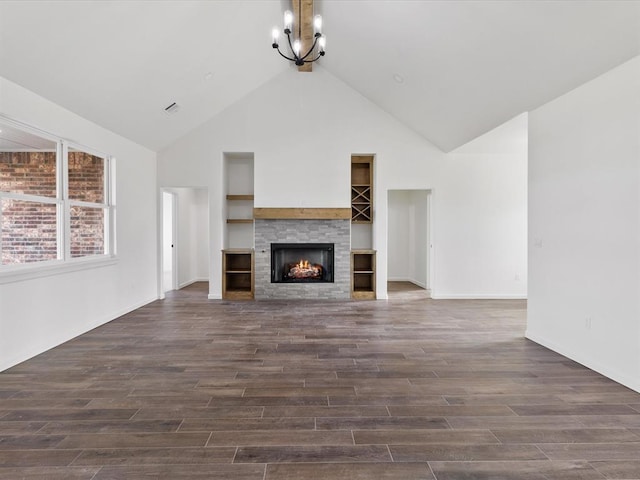 unfurnished living room featuring a tiled fireplace, dark hardwood / wood-style flooring, high vaulted ceiling, and a notable chandelier