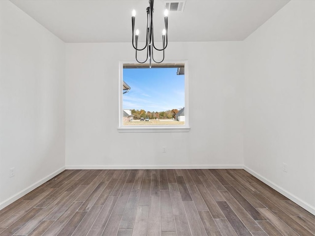 unfurnished dining area with dark hardwood / wood-style floors and a chandelier