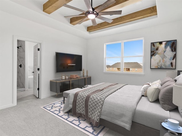 carpeted bedroom with a raised ceiling, connected bathroom, and ceiling fan