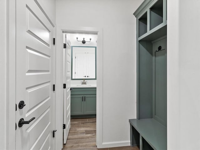 mudroom featuring sink and wood-type flooring