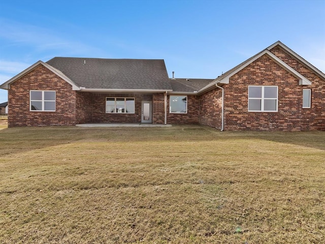 rear view of house featuring a patio area and a lawn