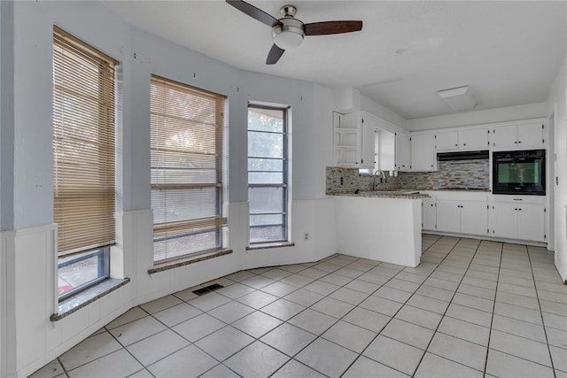 kitchen with oven, backsplash, and a wealth of natural light