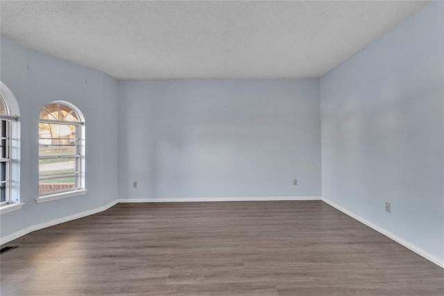 spare room with wood-type flooring and a textured ceiling