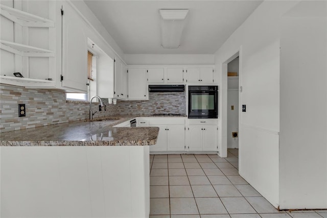 kitchen featuring kitchen peninsula, sink, tasteful backsplash, black oven, and white cabinetry