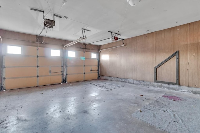 garage featuring wood walls and a garage door opener