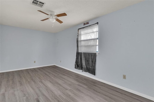 empty room featuring a textured ceiling, hardwood / wood-style flooring, and ceiling fan